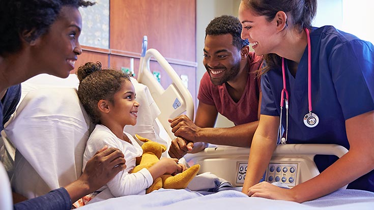 Image of two nurses talking with patient and her father