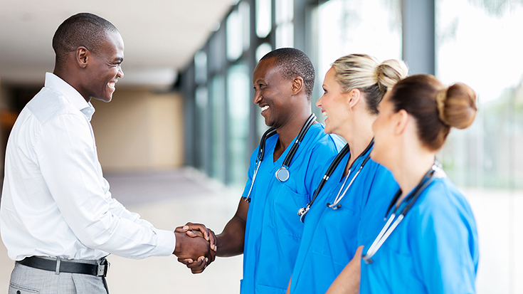 Image of man shaking hands with doctors