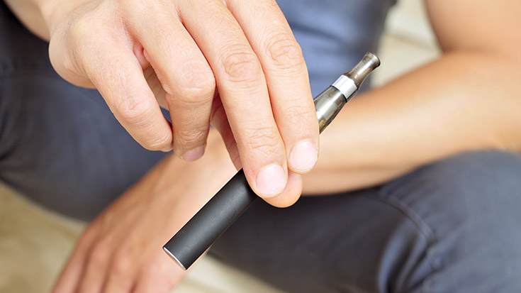 young man holding e-cig