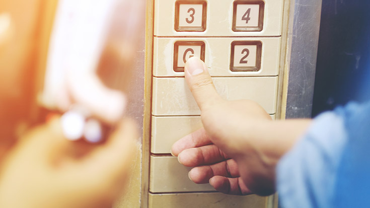 image of person pressing elevator floor button