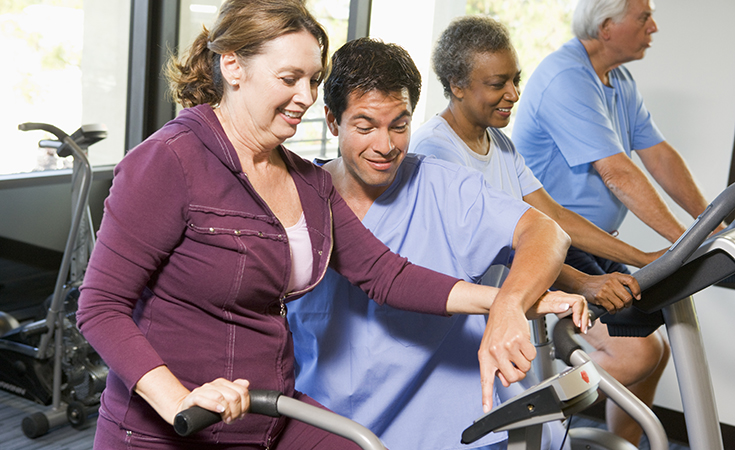 photo of woman on stationary bike being evaluated by RT