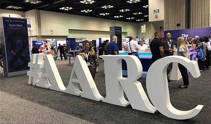 photo of Satterlee at AARC Congress 2017, standing with large #AARC sign