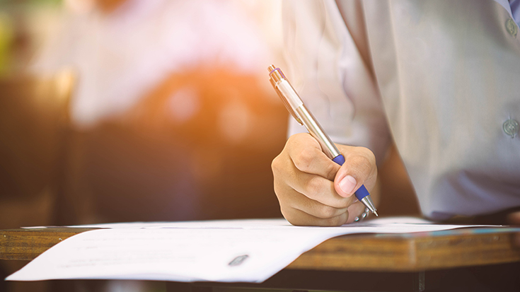 person writing on paper at table