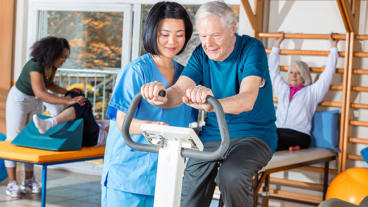 image of RT working with patient on exercise bike