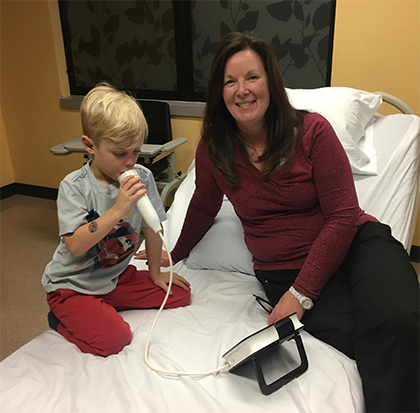 Julie Burmester sits with a young boy during testing.