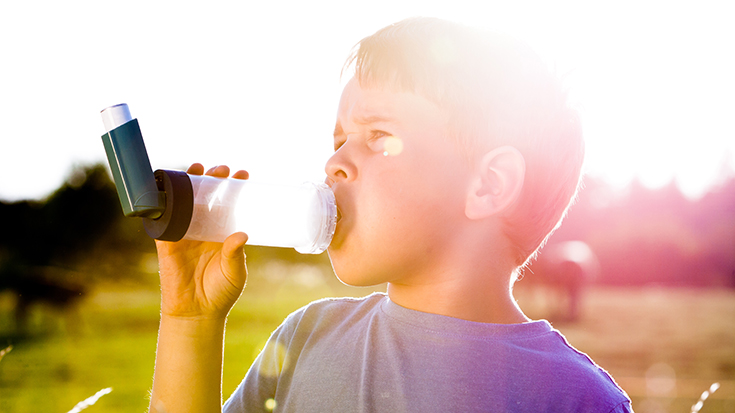 image of child using an inhaler with a spacer