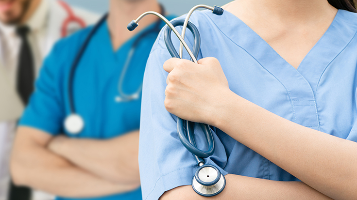 image of medical professionals with foreground individual holding stethoscope