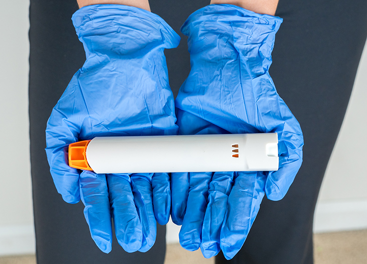 photo of medical professional holding an epinephrine injector