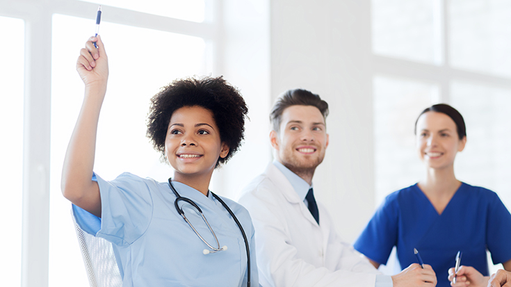 image of young health professional raising hand while in meeting