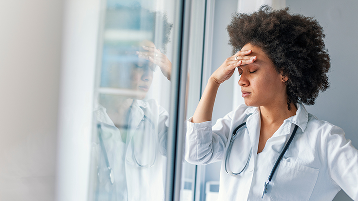 photo of female medical professional holding forehead