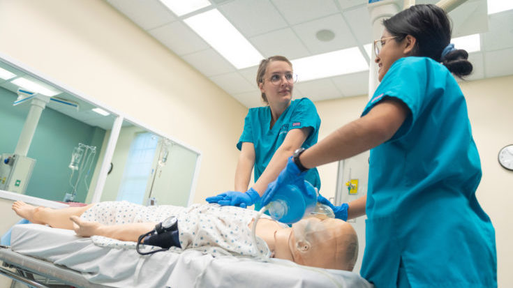 Image of two nurses helping a patient