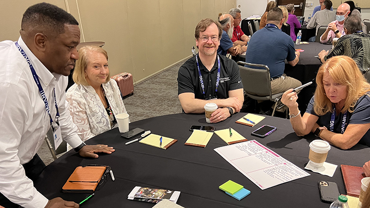Joel Brown, Lynda Goodfellow, Carl Hinkson, and Diane Lewis brainstorm together.
